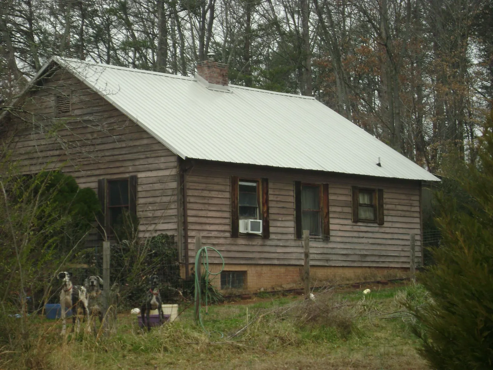 White metal roof on an old wood sided farmhouse, from a Metal Roof Installation job in Rochester